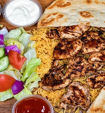 Grilled chicken pieces on rice with naan, garden salad and dipping sauces